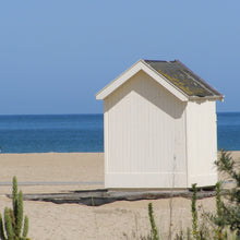 Load image into Gallery viewer, Beach Hut on a sandy beach with the blue sea behind.
