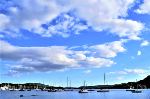 A view of boats on Lake Windermere with a cloudy sky.